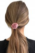 Rosa satinrose i håret på hvid baggrund